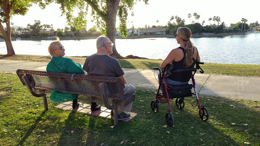 A group of people enjoying a serene moment by the lake during sunset.
