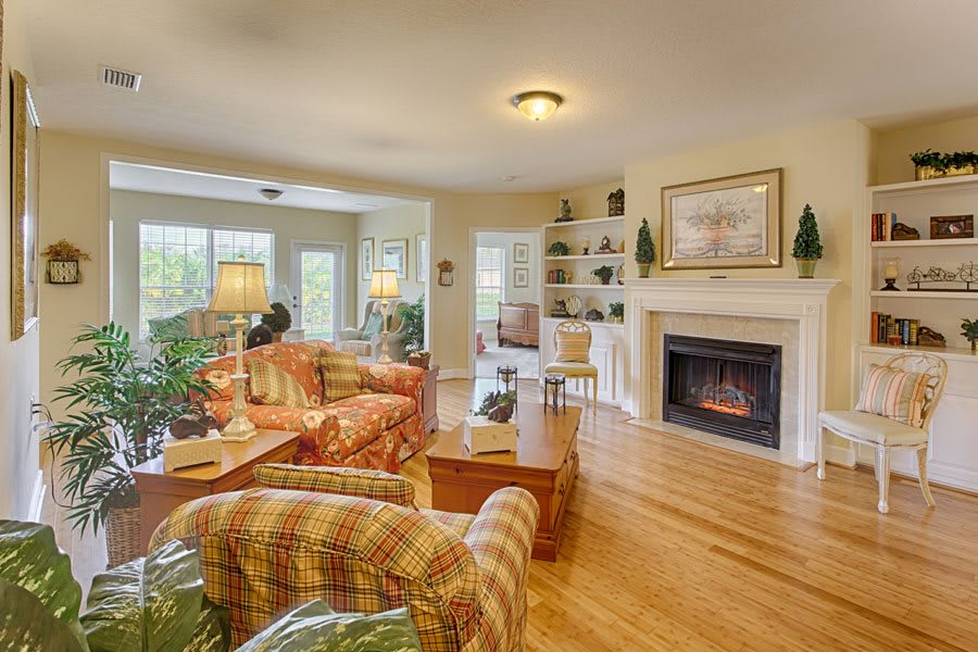 A cozy living room with a fireplace, comfortable seating, and bright natural light.