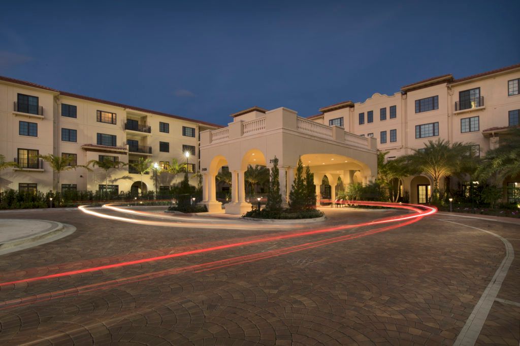 A beautifully lit hotel entrance at night with light trails on the driveway.