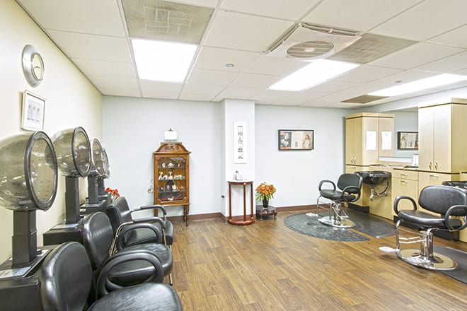 A well-lit salon interior with a waiting area and hair styling stations.
