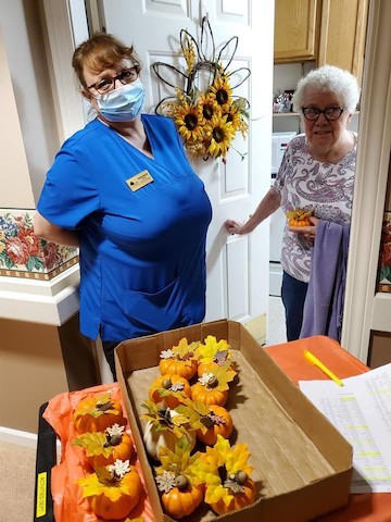 Residents engage in a festive autumn activity, creating decorative crafts together.