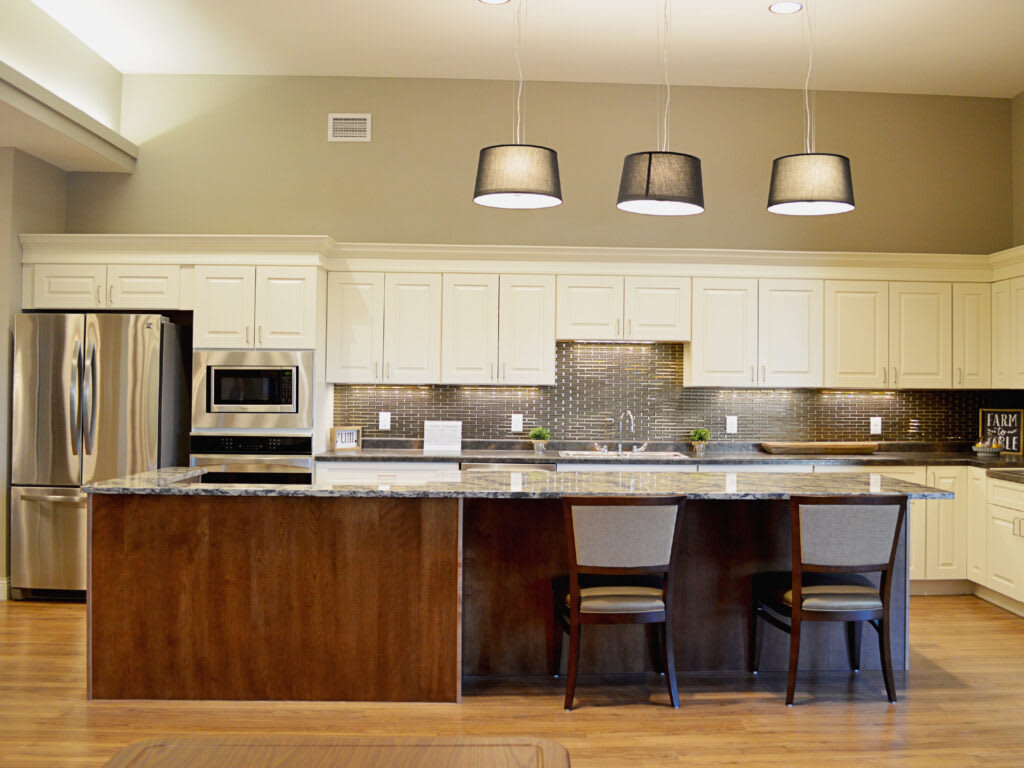 Modern kitchen with sleek design featuring stainless steel appliances and a spacious countertop with bar stools.