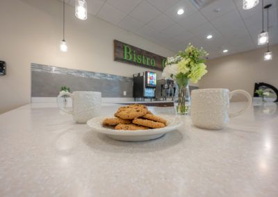 A cozy cafe setting with cookies and coffee mugs on a countertop.