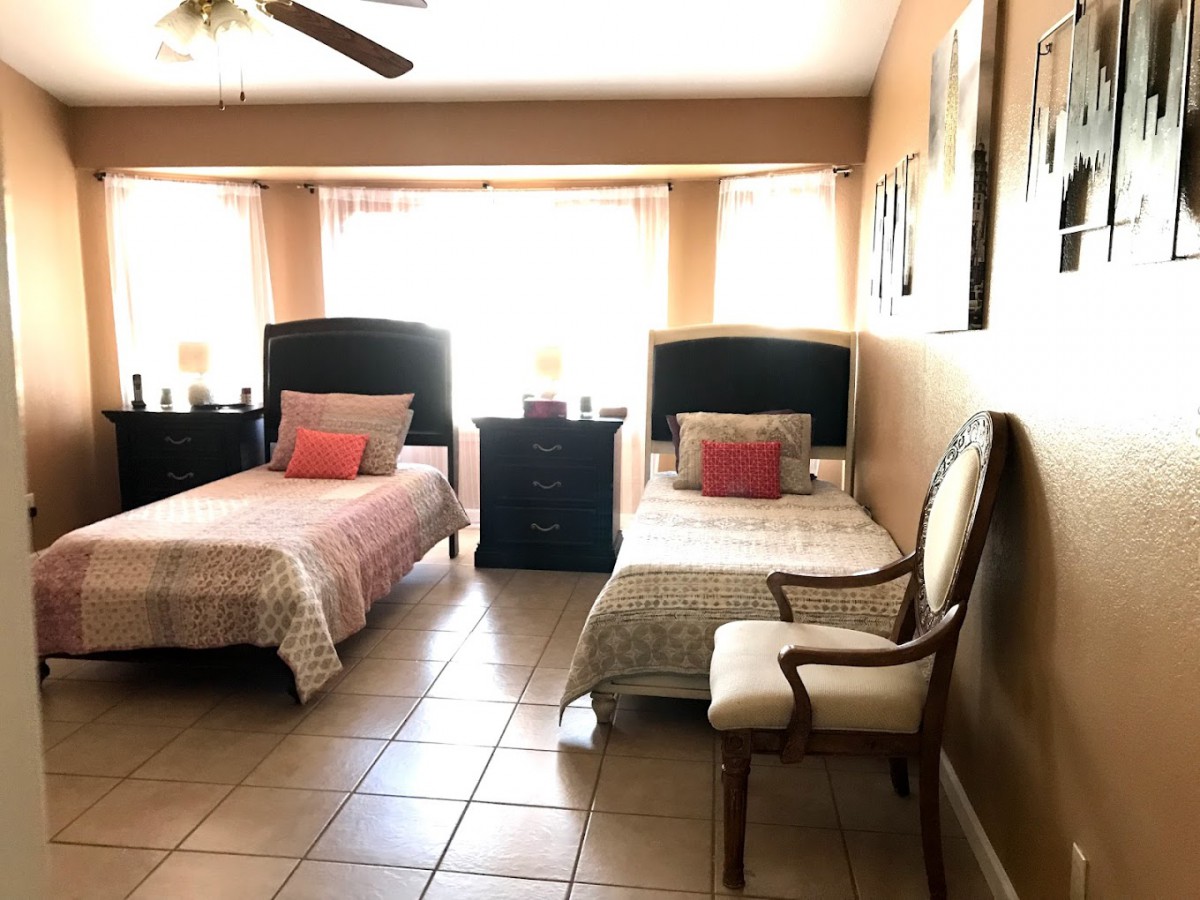 A cozy bedroom with two twin beds and elegant decor.