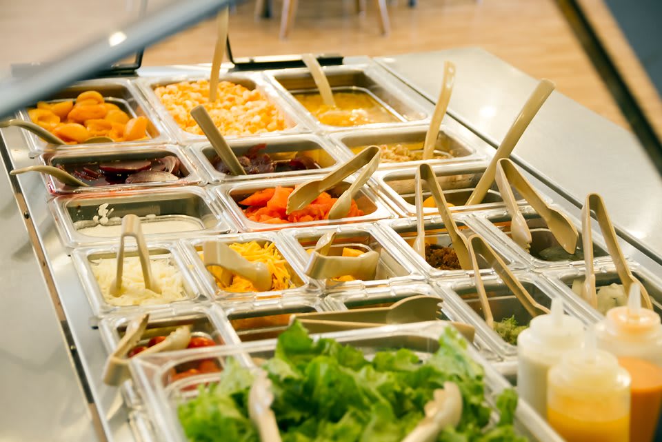 A vibrant salad bar featuring a variety of fresh ingredients and dressings.