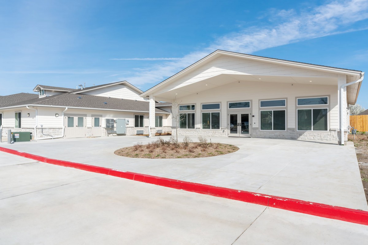 A modern building with a wide entrance and a clear blue sky.
