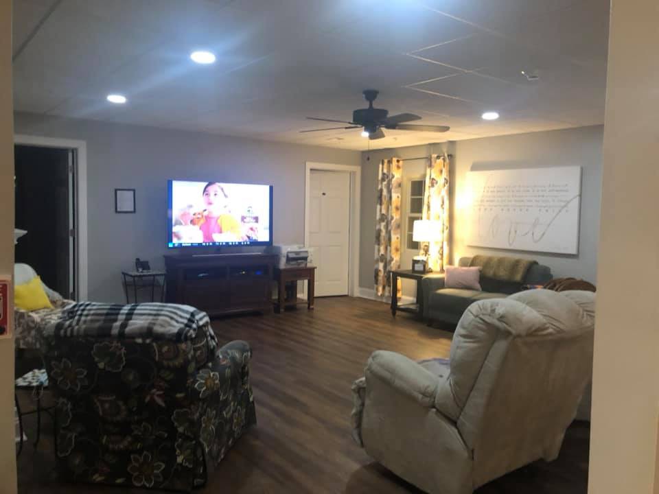 A cozy living room with comfortable seating, a television, and soft lighting.