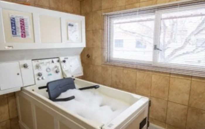A room featuring hydrotherapy equipment with a bubbling water tub for therapeutic use.
