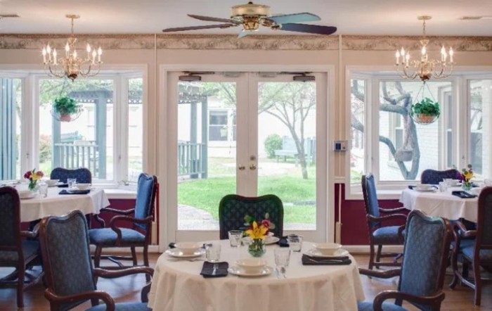 A beautifully set dining room table with elegant decor and large windows providing natural light.