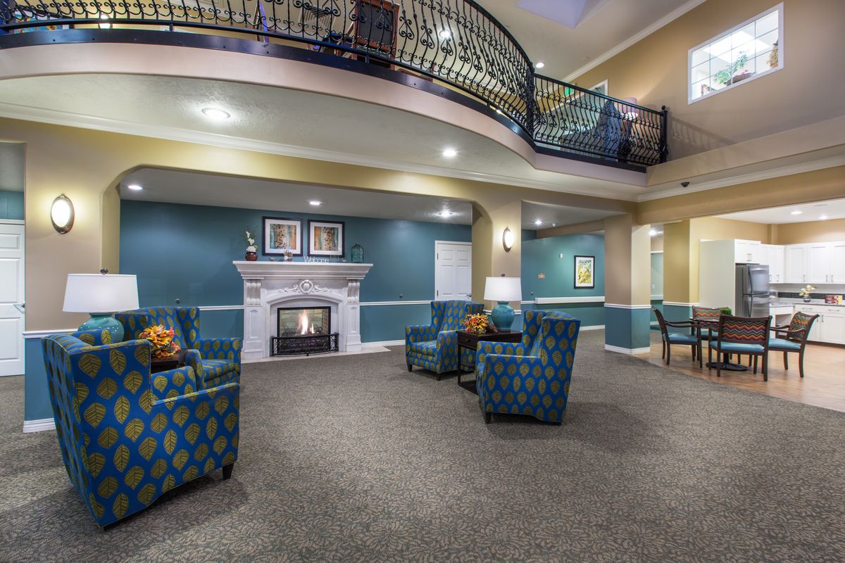 A spacious lobby with cozy armchairs, a fireplace, and an elegant balcony.