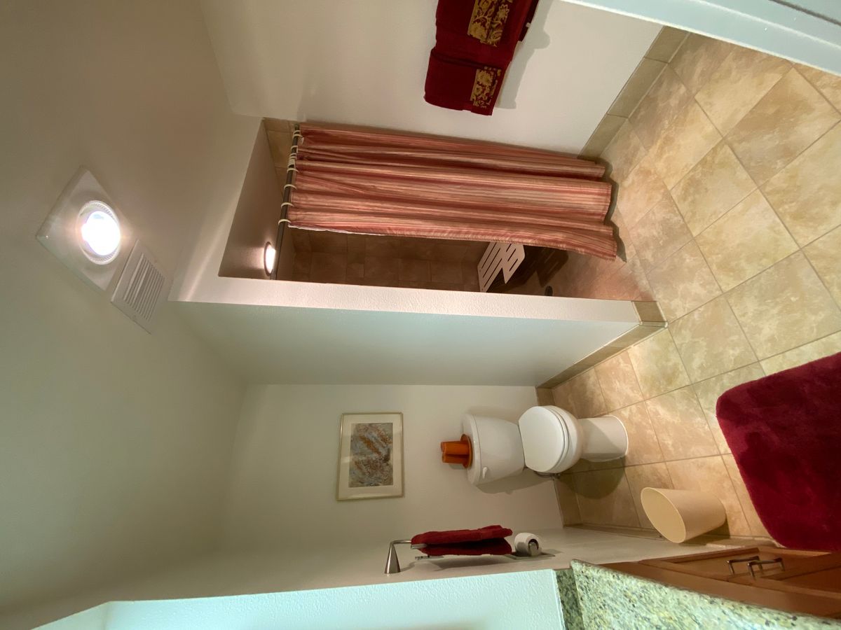 A clean and organized bathroom with a shower, toilet, and neatly arranged towels.