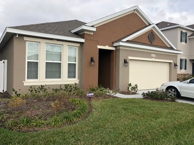 A suburban residential house with a neat lawn and driveway.