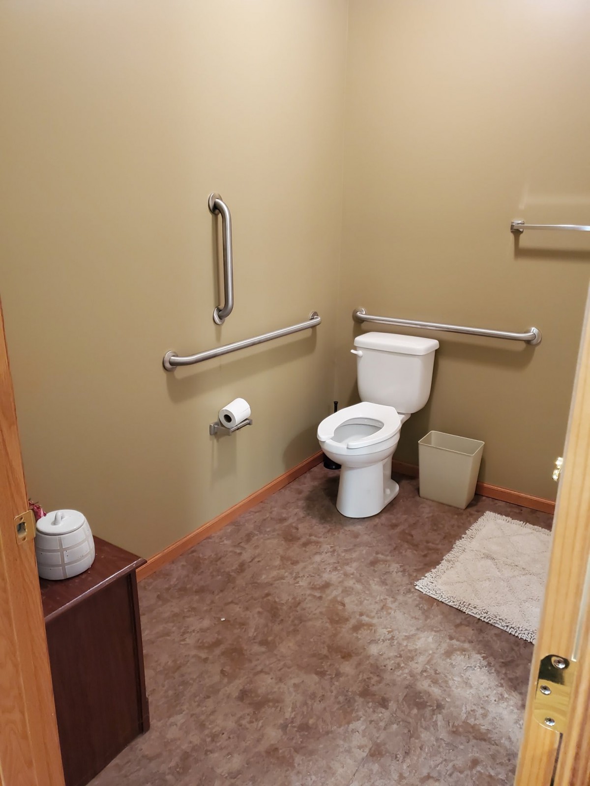 A clean and accessible bathroom with safety handrails.