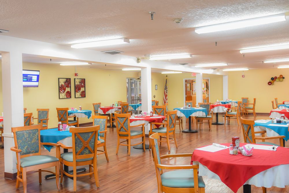Cozy dining area with colorful tablecloths and wall art.