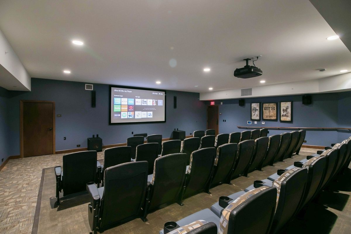 A cozy home theater room equipped with comfortable seating and a large projection screen.