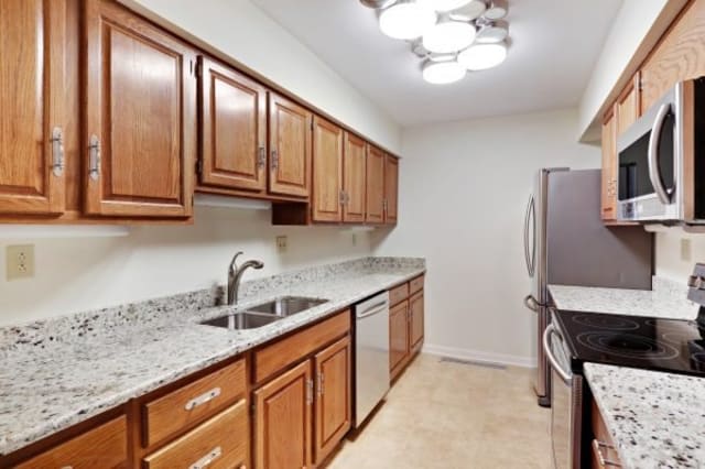 Modern kitchen with wooden cabinets and granite countertops.