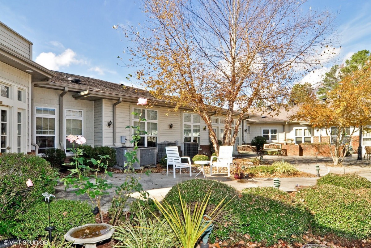 A serene backyard garden with patio seating and lush greenery.