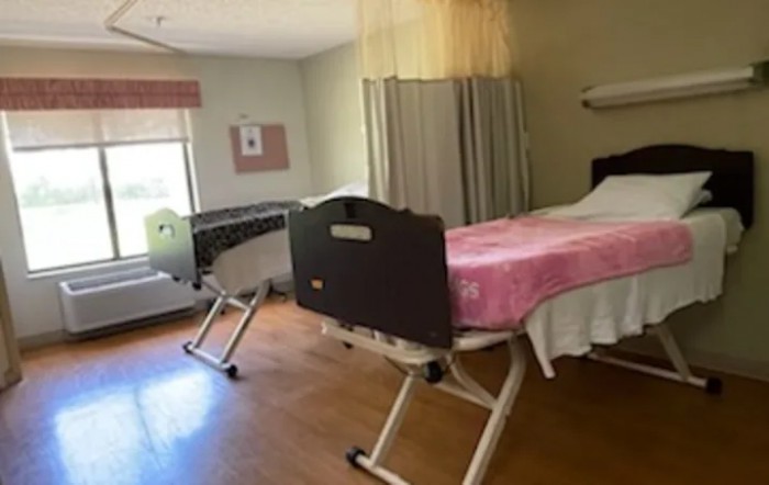 A healthcare room with adjustable beds and privacy curtains.