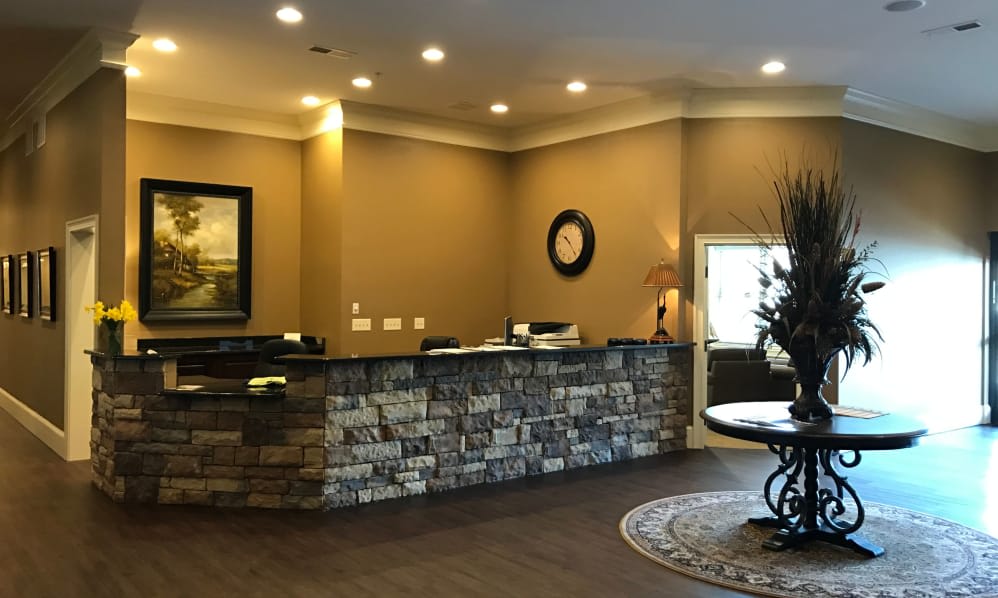 A warmly lit hotel lobby with a stone reception desk and elegant decor.
