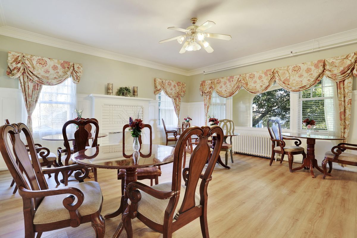 A traditional dining room with elegant wooden chairs and a ceiling fan.