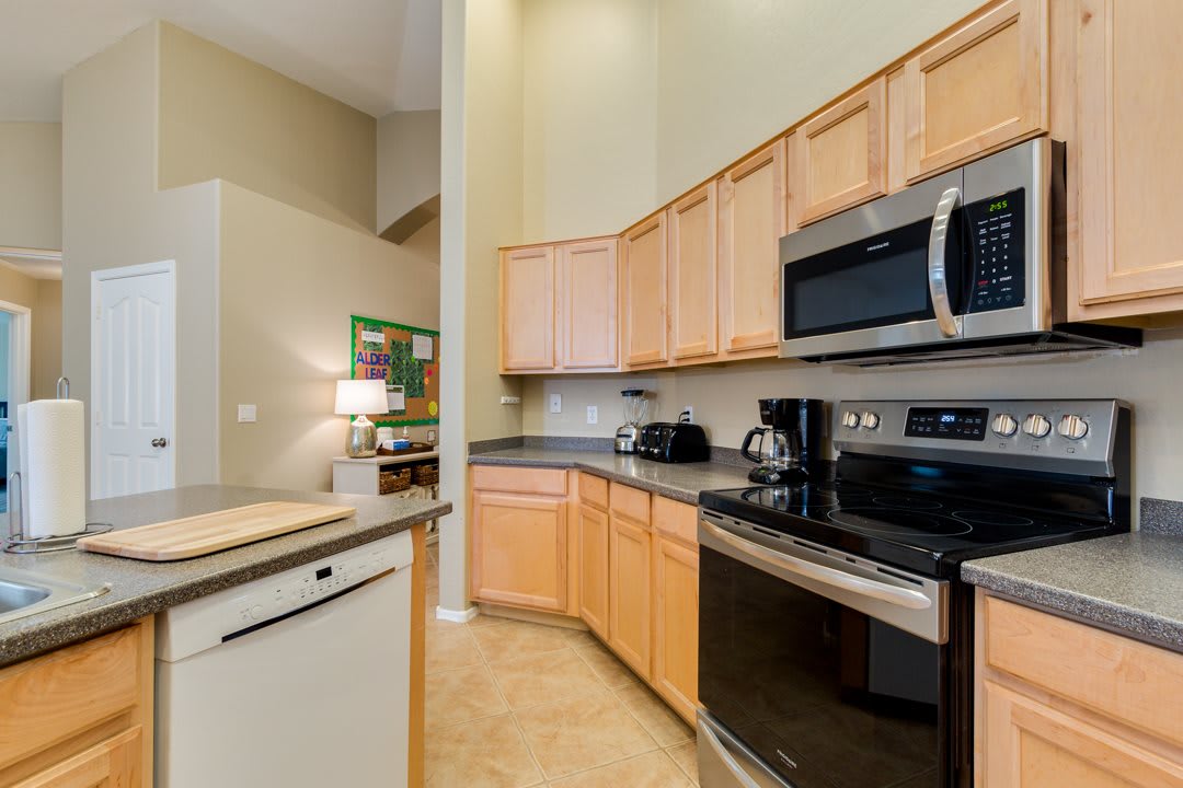 A modern kitchen featuring wooden cabinets and stainless steel appliances.