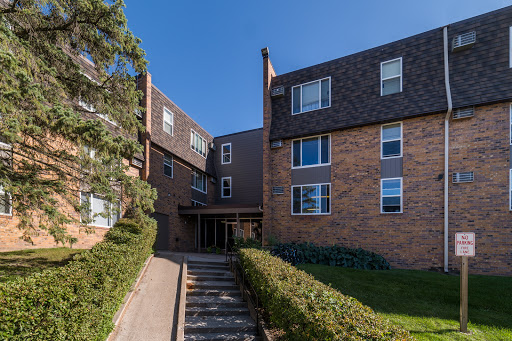 A modern brick apartment building with a landscaped entrance.