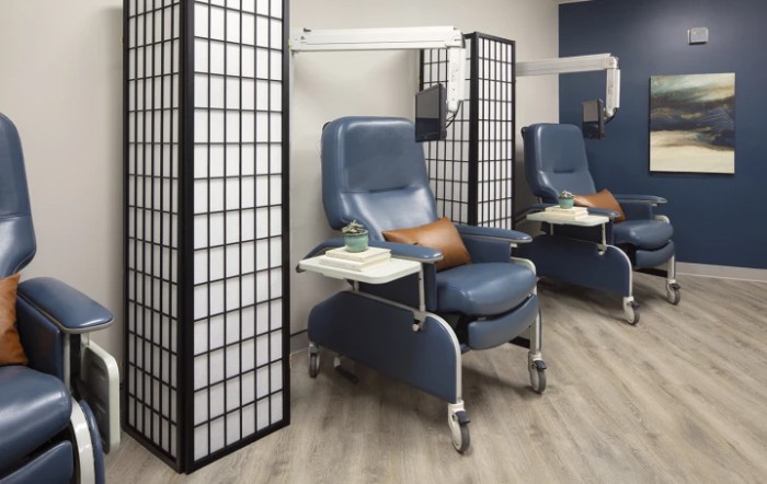 A modern healthcare setting with treatment chairs and privacy screens.