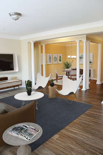 A stylish and modern living room featuring sleek furniture, an open layout, and warm color accents.