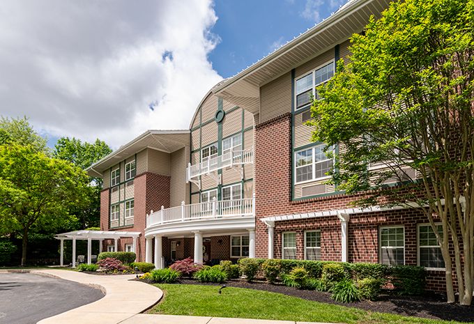 A modern residential building with landscaped surroundings and a clear sky.