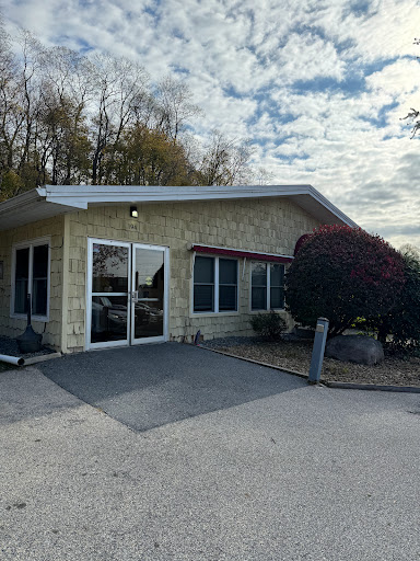 A cozy building with a welcoming entrance, set against a cloudy sky.