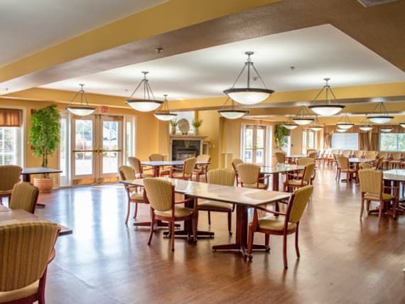 A spacious and well-lit dining area with wooden tables and chairs.
