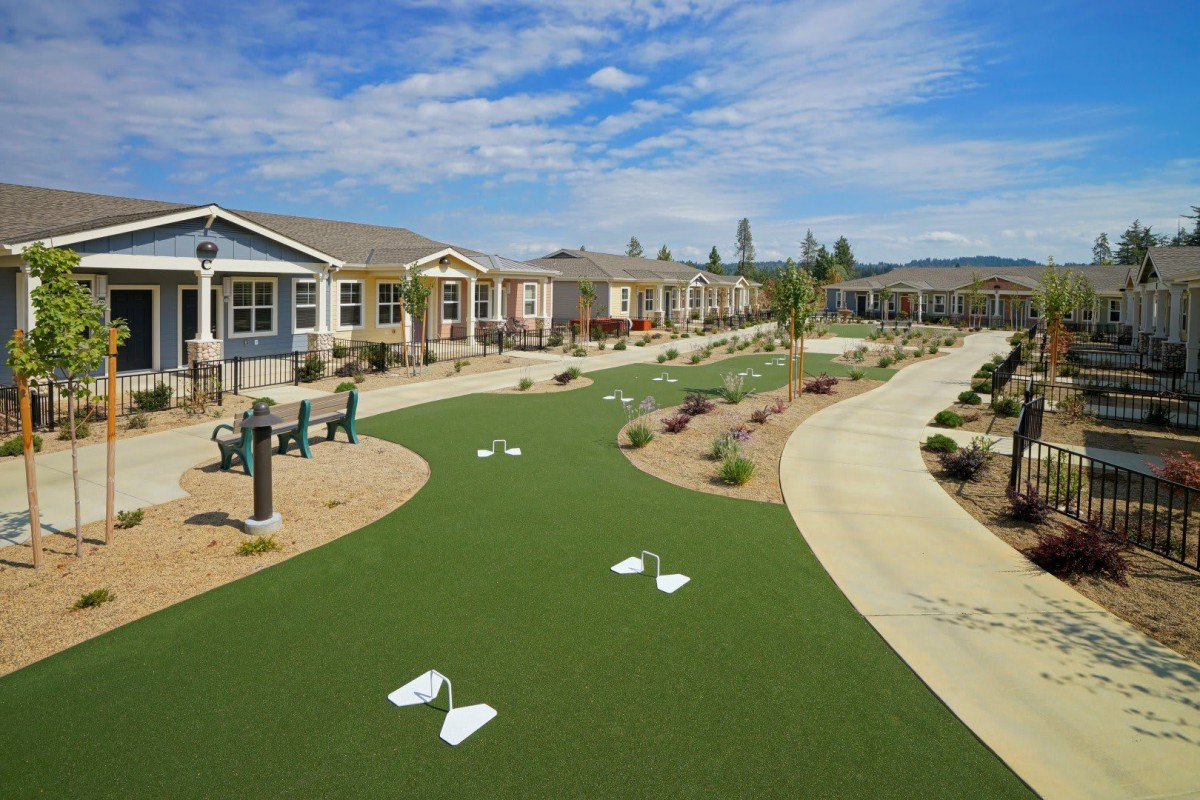 A community with a well-maintained green pathway and attractive landscaping.