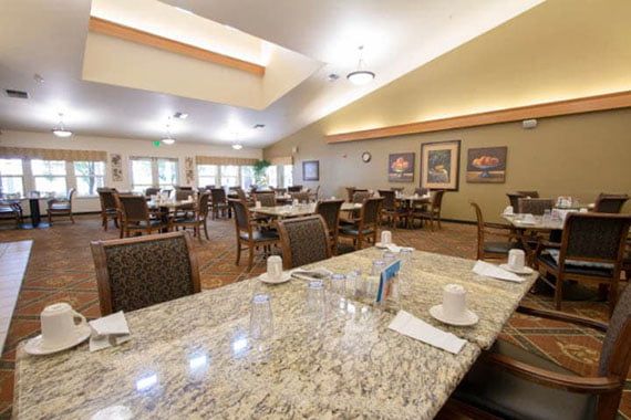 A well-lit dining area with neatly arranged tables and chairs, ready for service.