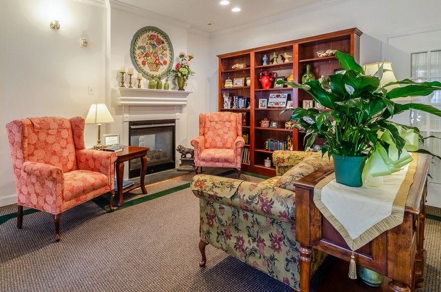 A cozy living room with a fireplace, bookshelves, and comfortable seating.