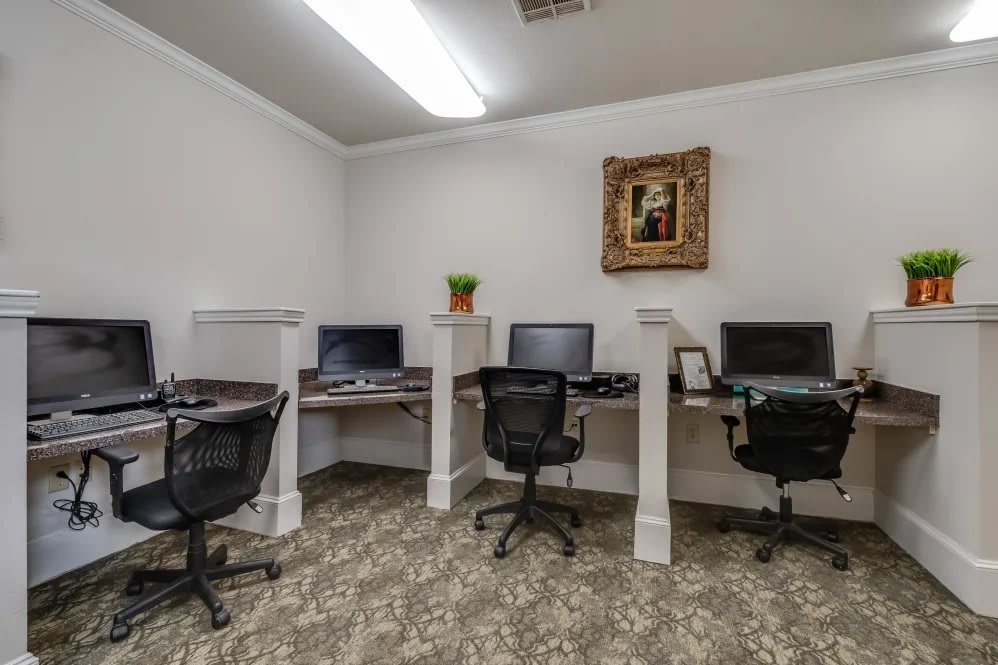A small office room with three computer workstations and chairs.