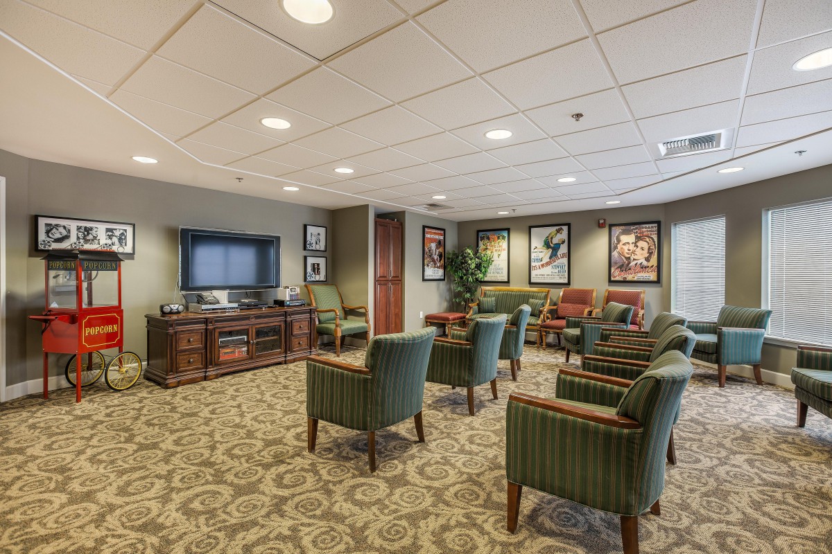 A comfortable waiting room with multiple chairs and a TV, decorated with framed artwork.