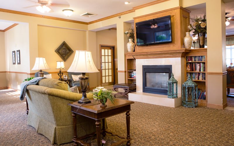 A cozy living room with a fireplace, sofa, and TV.