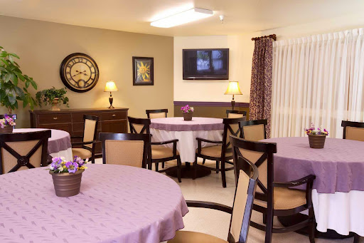 A cozy dining area featuring elegant tables and chairs, complemented by warm lighting and tasteful decor.
