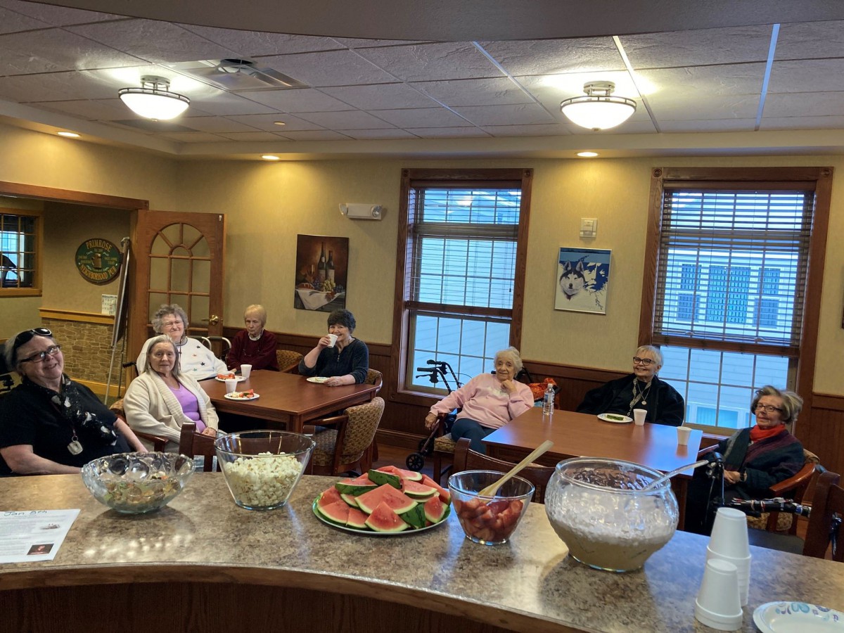 A social gathering of seniors enjoying a meal in a cozy indoor setting.