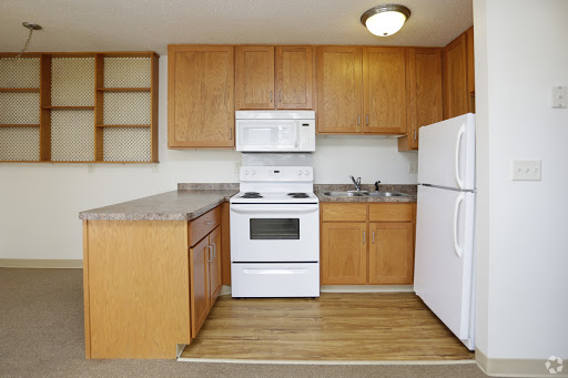 A cozy kitchen equipped with essential appliances and wooden cabinetry.