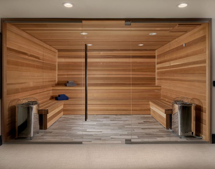 A modern wooden sauna with benches and buckets, designed for relaxation and wellness.