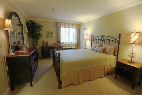 A cozy bedroom with elegant furnishings and natural lighting.