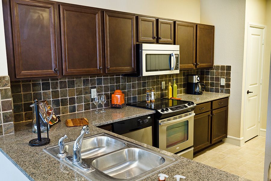 A modern kitchen with stainless steel appliances and granite countertops.