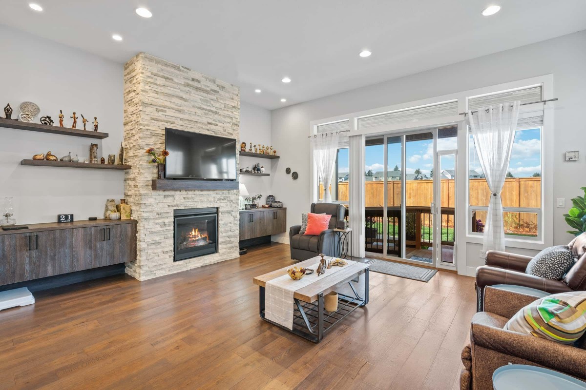 A modern living room with a fireplace and large sliding glass doors providing ample natural light.