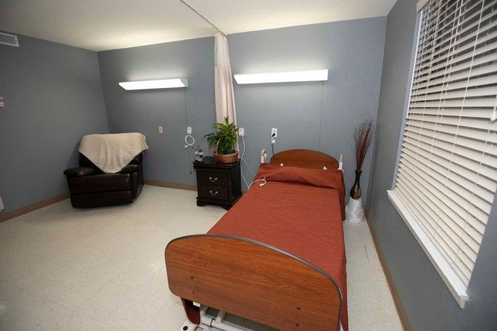 A hospital room with a single bed and medical equipment.