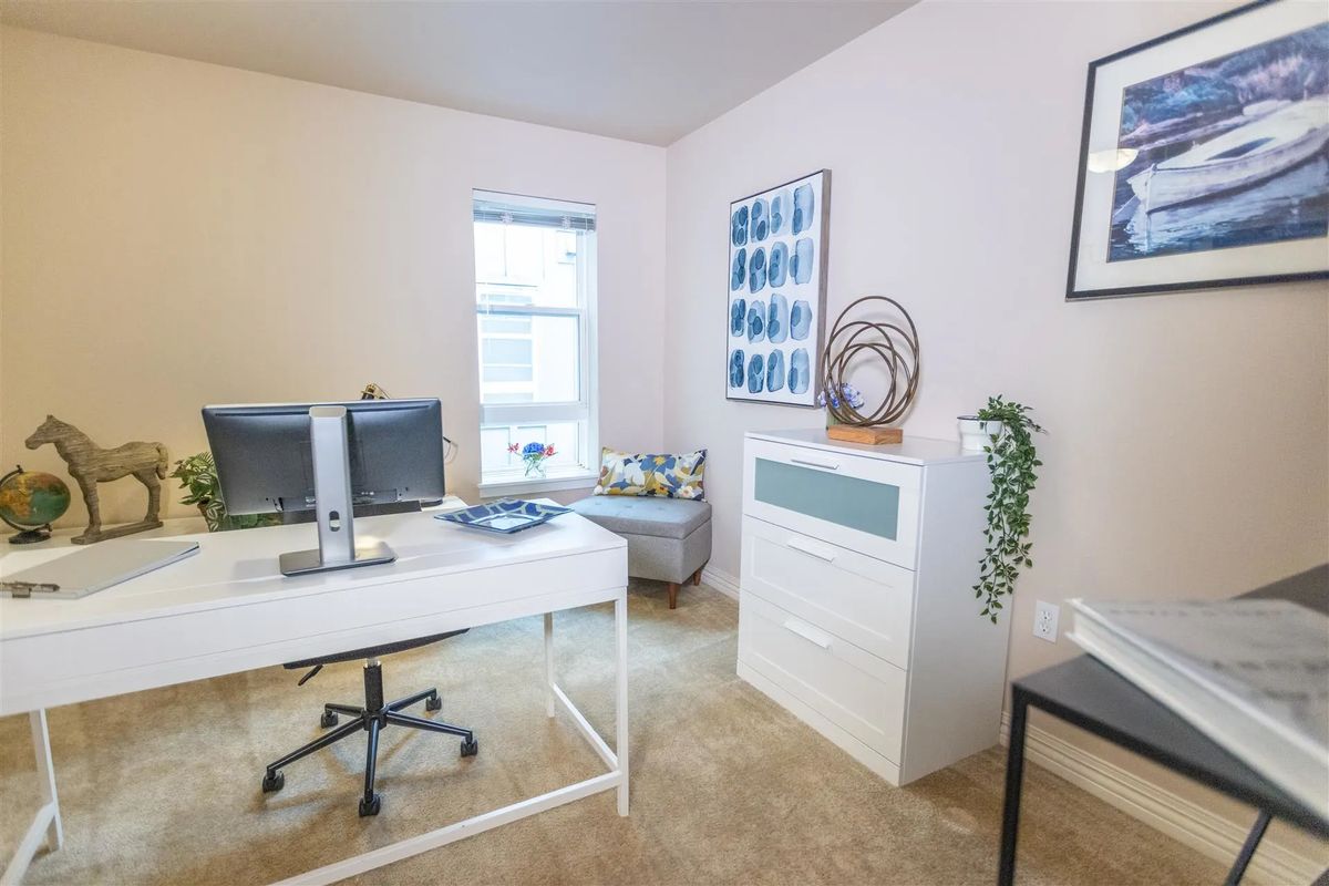 A bright, modern office space with a white desk and minimalist decor.
