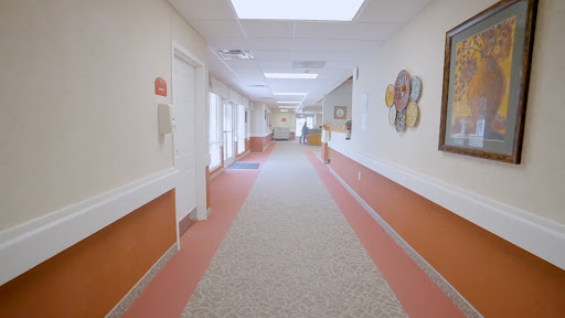 A well-lit corridor featuring colorful walls and a carpeted floor.