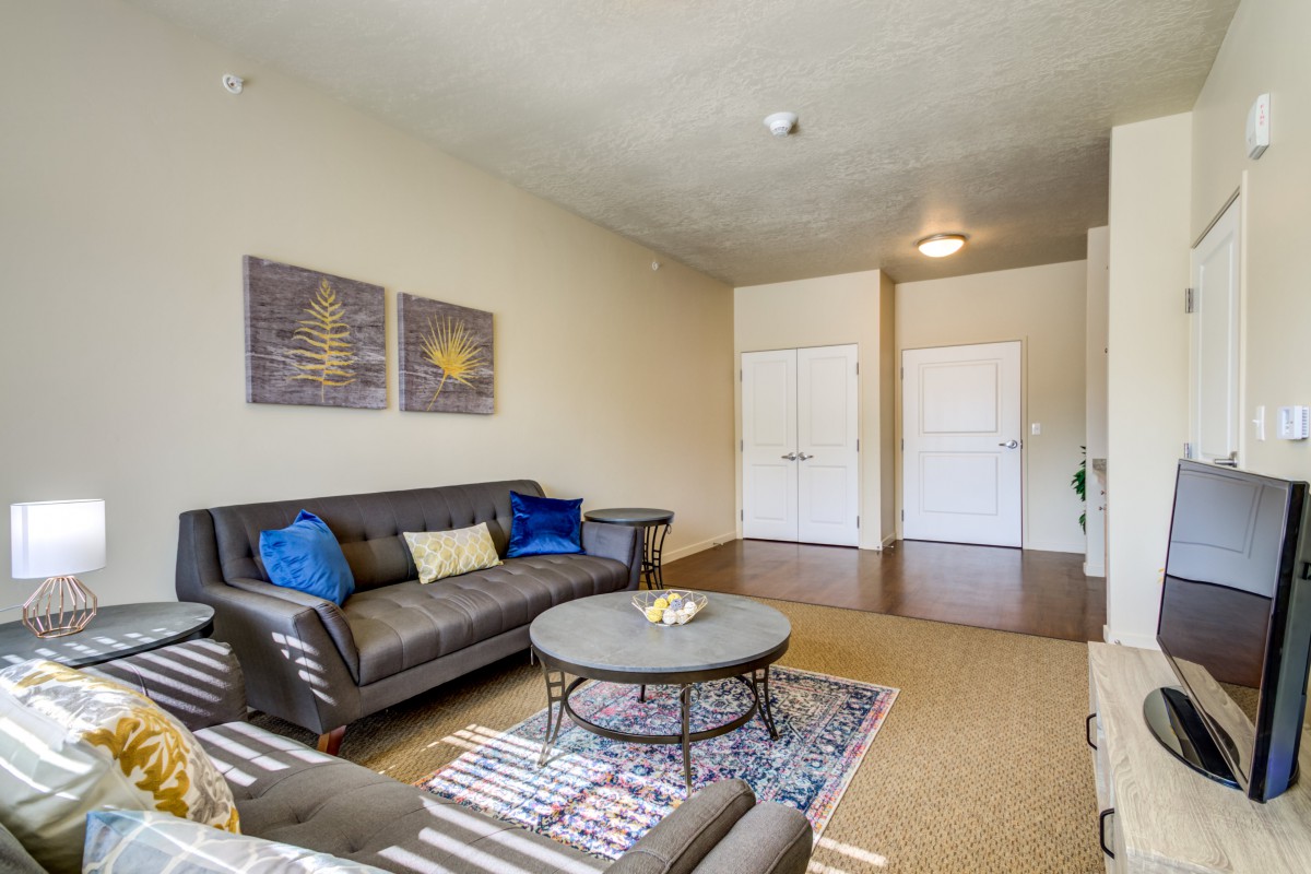 A cozy living room with a comfortable sofa, a round coffee table, and decorative artwork on the wall.