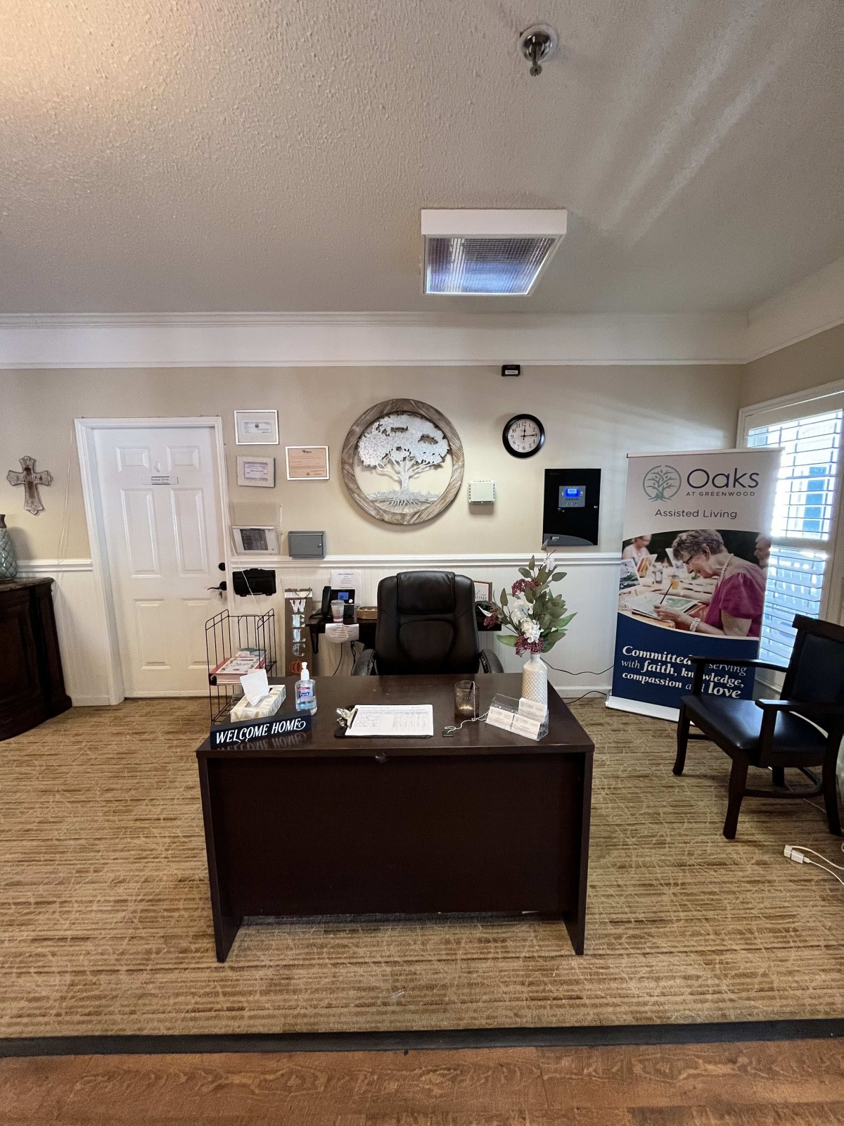 A well-organized office with a central desk, comfortable chairs, and informative brochures.