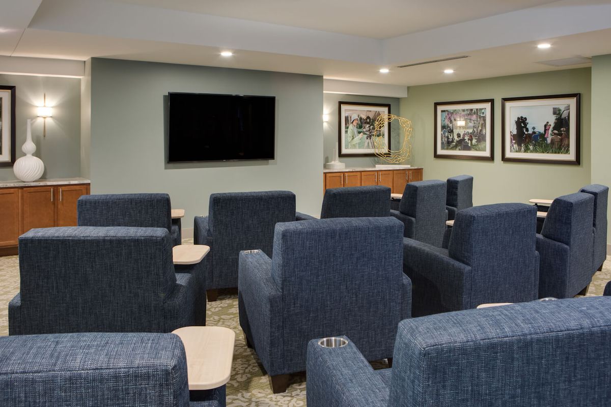 A small theater room with comfortable seating and a large television.